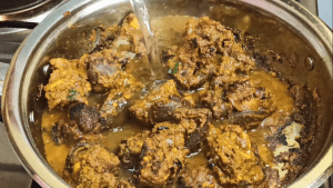 Add hot water and cook the goat meat