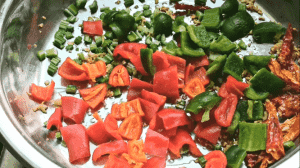 Next, add 2 tbsp of chopped celery and chopped capsicums; stir fry for 2 minutes until the peppers are soft.