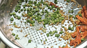 Add 1 tbsp of sesame oil and go in with the garlic, ginger, and red chili peppers. Stir fry for 30 seconds.
