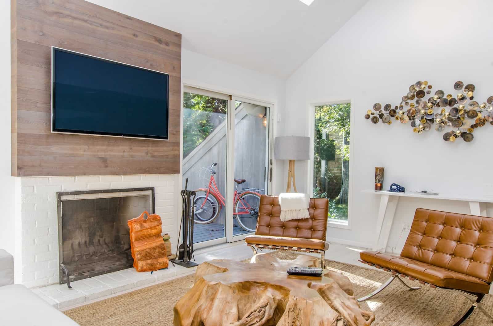 two tufted brown leather chairs in front of brown wood stump center table